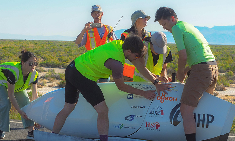 Image of member of monash human power team with their vehicle in the desert